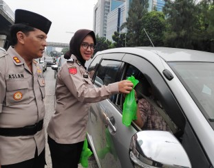 Ketgam : Polwan Polres Jakarta barat saat membagikan takjil ke pengendara